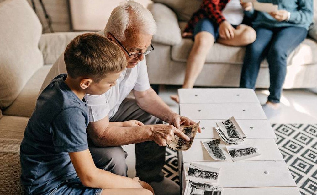 Grandfather helping Grandson discover his family story. Family history is important for children.